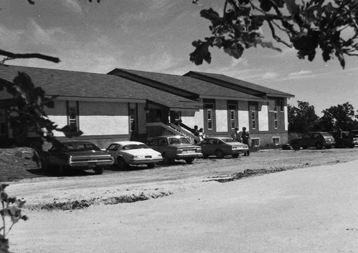 Exterior of Friendship Baptist on a Sunday morning, cars parked outside the building
